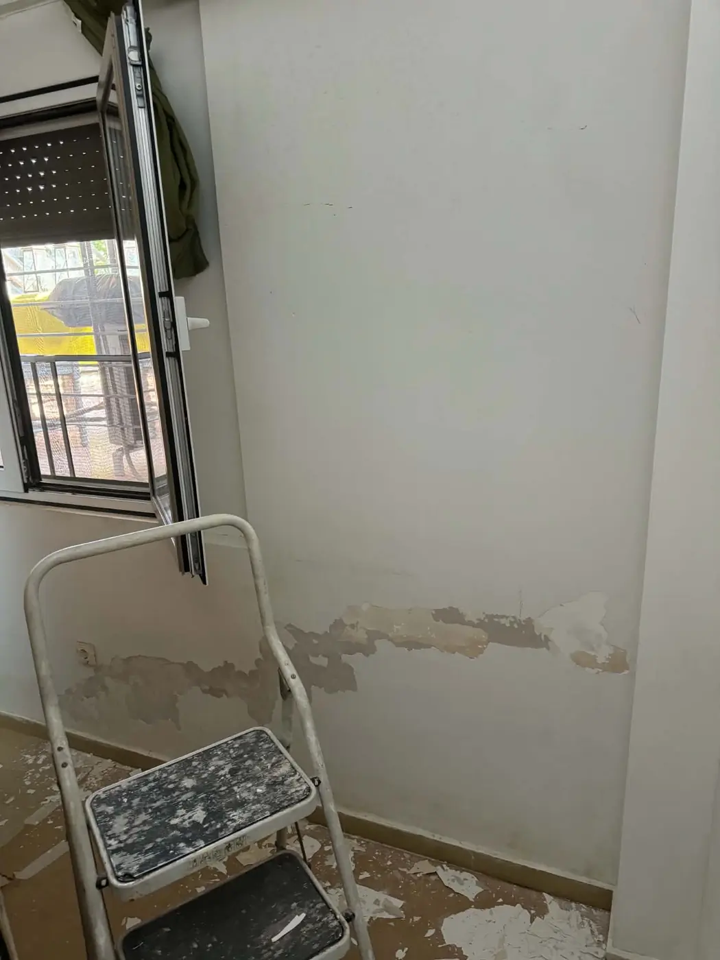 Ξύσιμο παλιού χρώματος σε τοίχο κάτω από παράθυρο στην Επανομή